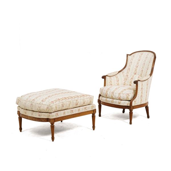 Poltrona con panchetto in noce intagliato. XVIII secolo