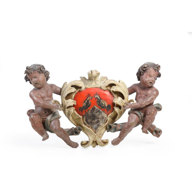 Due puttini che reggono uno stemma, fregio in legno laccato  - Auction Italian Mansions - Cambi Casa d'Aste