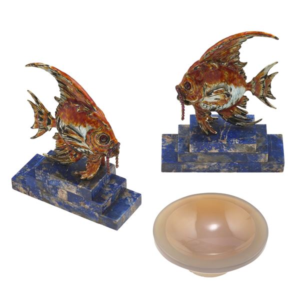 A. Ravasco. Trittico composto da due pesci in metallo dorato, decorati con smalti policromi e impreziositi  [..]