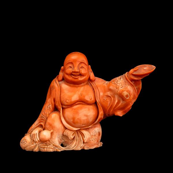 Rare and finely carved figure of Budai in red coral with engraved floral decorations, China, Qing Dynasty, late 19th century