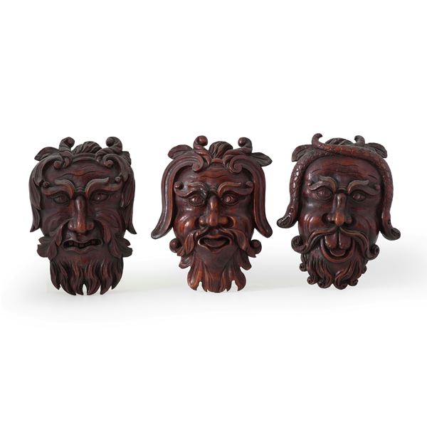 Tre mascheroni in legno intagliato