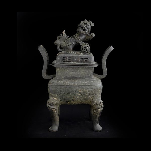 Incensiere in bronzo con decori in stile arcaico incisi a motivi geometrici, mascheroni leonini e coperchio  [..]