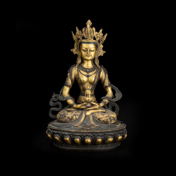 Figura in bronzo dorato raffigurante Buddha Amitayus incoronato seduto su fiore di loto con inserti di pietre dure,  Tibet, XX secolo