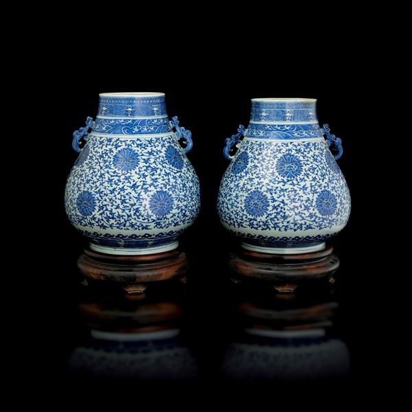 Pair of 'Hu' vases in blue and white porcelain with naturalistic motifs depicting lotus flowers and a wave band surmounted by geometric patterns with stylized dragons, handles shaped as bats, China, Qing Dynasty, Guangxu period (1875–1908)