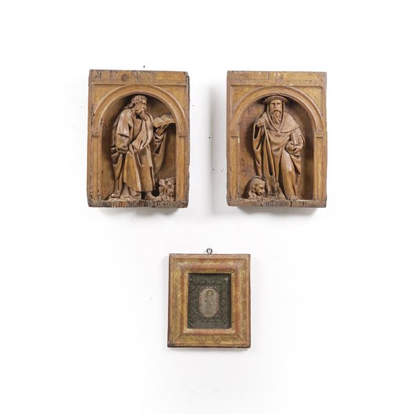 Coppia di rilievi in legno scolpito con Santi e un ricamo con Gesù Bambino