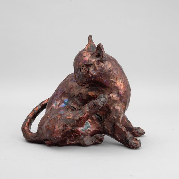 Scultura raffigurante gatto in terracotta con decoro di smalti e lustri metallici.