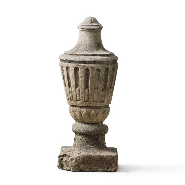 Un elemento decorativo in pietra a foggia di vaso costolato
