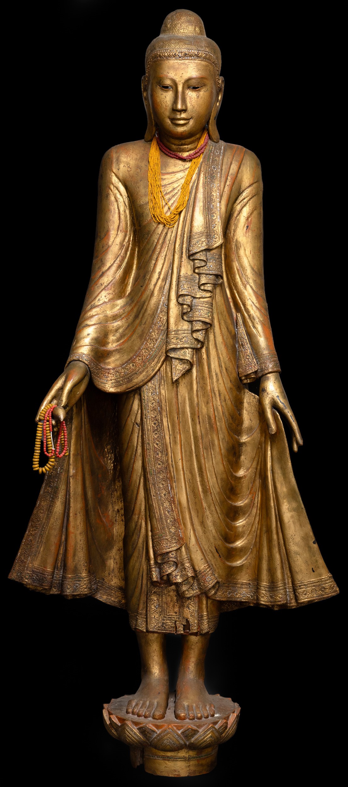 Figura di Buddha stante su fiore di loto, legno dorato con inserti in pietre dure, Birmania, XIX ...