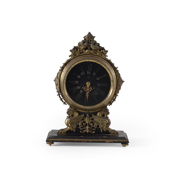 Pendola da tavolo in legno intagliato e metallo dorato. XX secolo