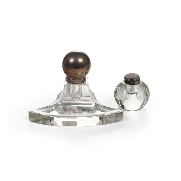 Un calamaio in vetro con tappo in argento e uno con tappo in metallo