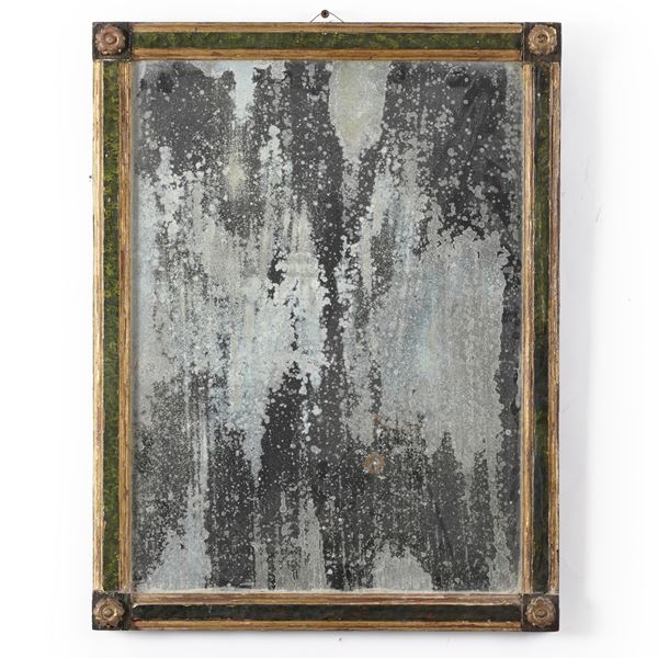 Cornice in legno intagliato, dipinto e dorato.