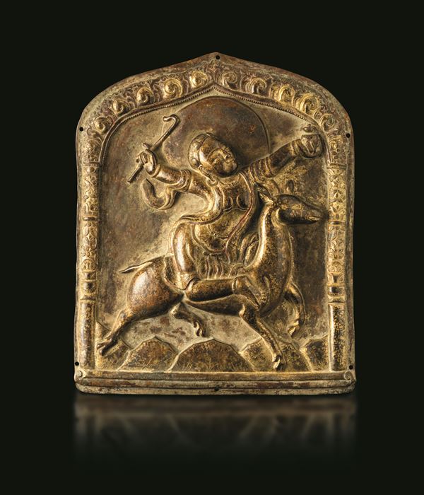 Gilt repoussé copper temple plaque with traces of red polychrome depicting a horseman, Tibet, 17th century.