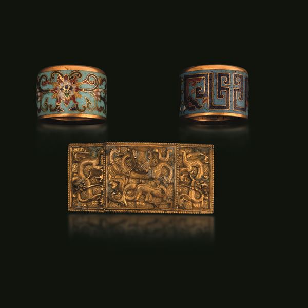 Lotto composto da due anelli a smalti policromi cloisonné e fibbia in bronzo con decori a rilievo, Cina, Dinastia Qing, fibbia epoca Qianlong (1736-1796) anelli XIX secolo