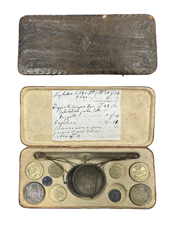 Astuccio contenente bilancino con nove pesi monetali.