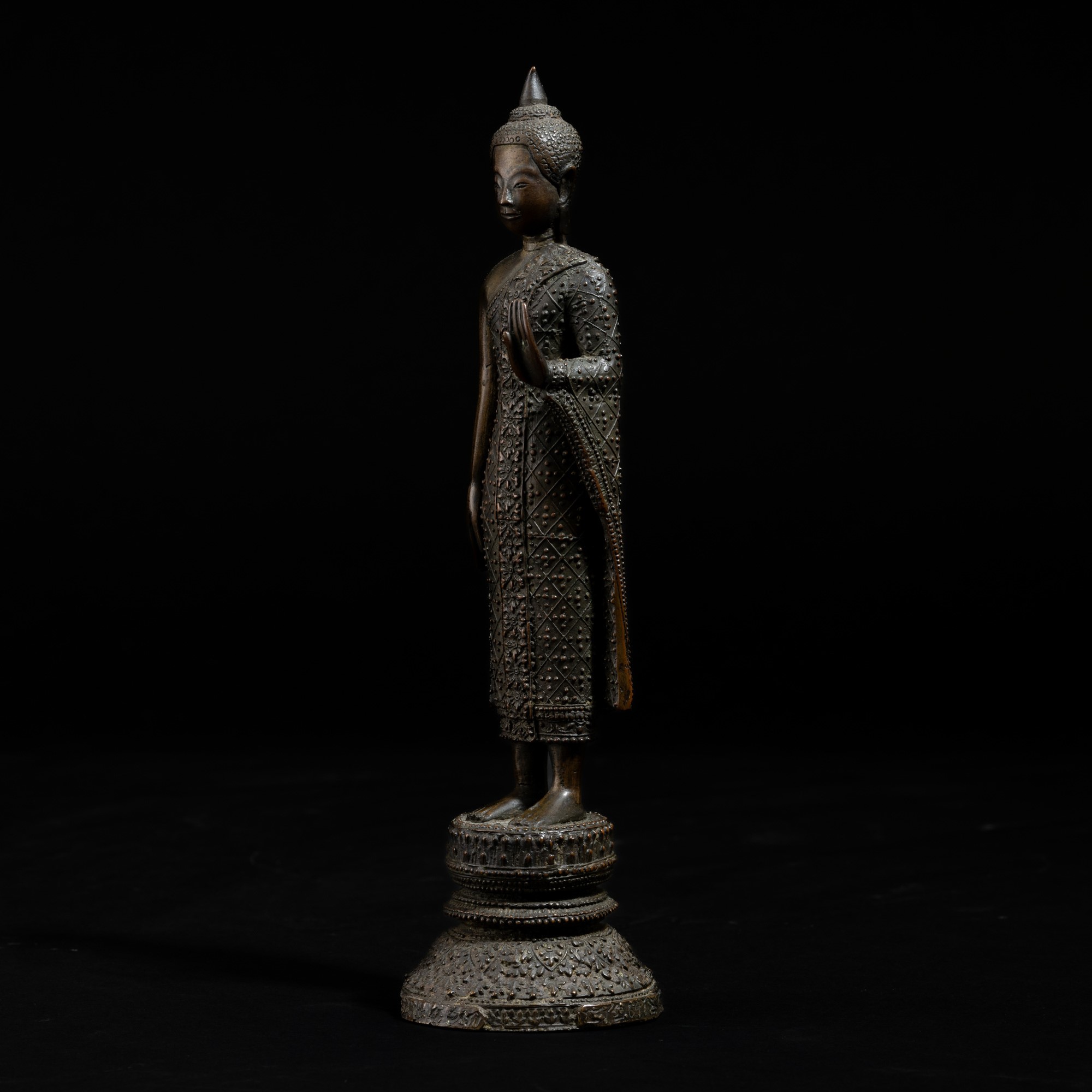 Thailandia, XIX secolo, Figura di Buddha stante in bronzo con decori a rilievo