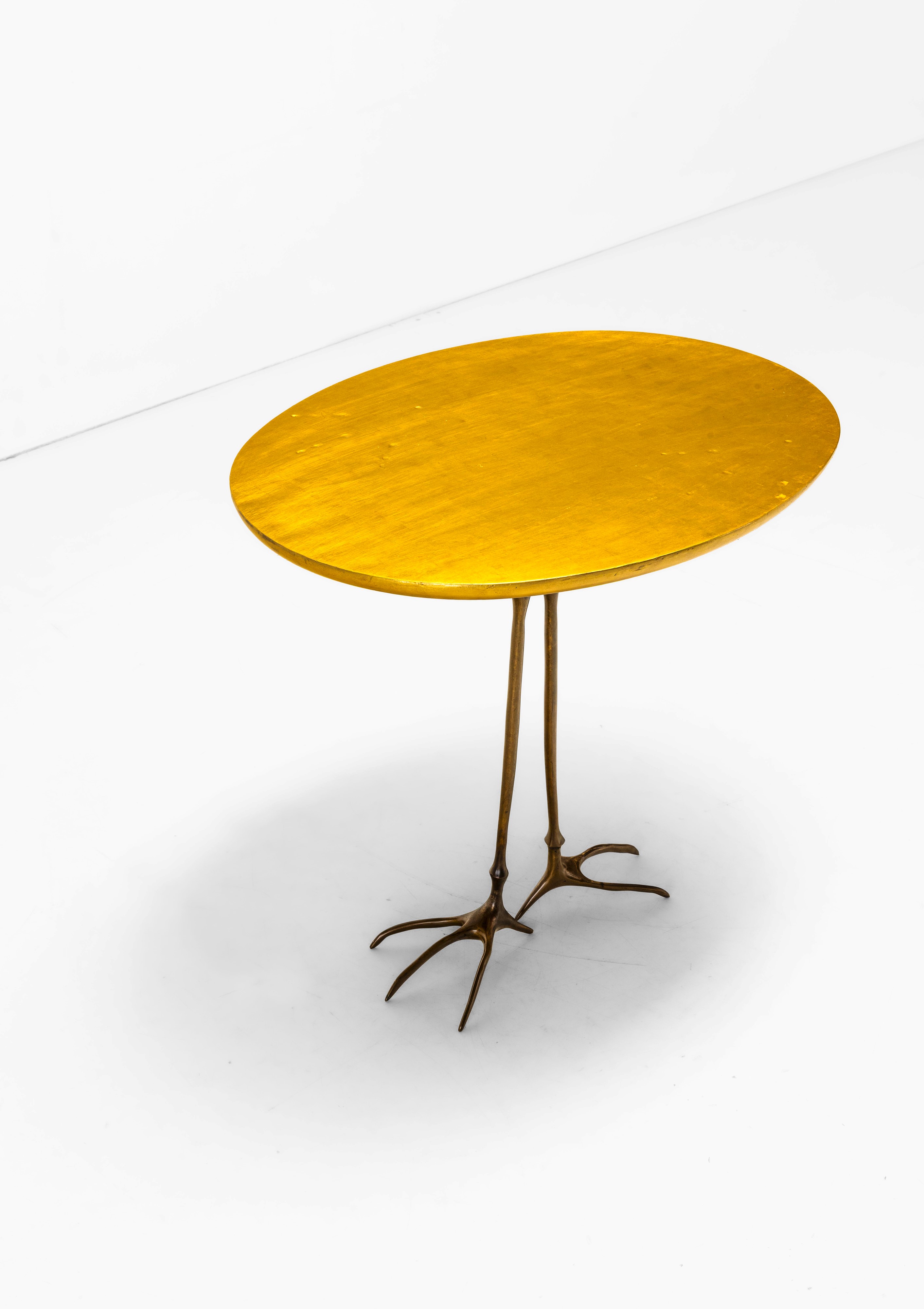 Meret Oppenheim - Tavolo occasionale mod. Traccia, fusione di bronzo dorato e legno a foglia oro