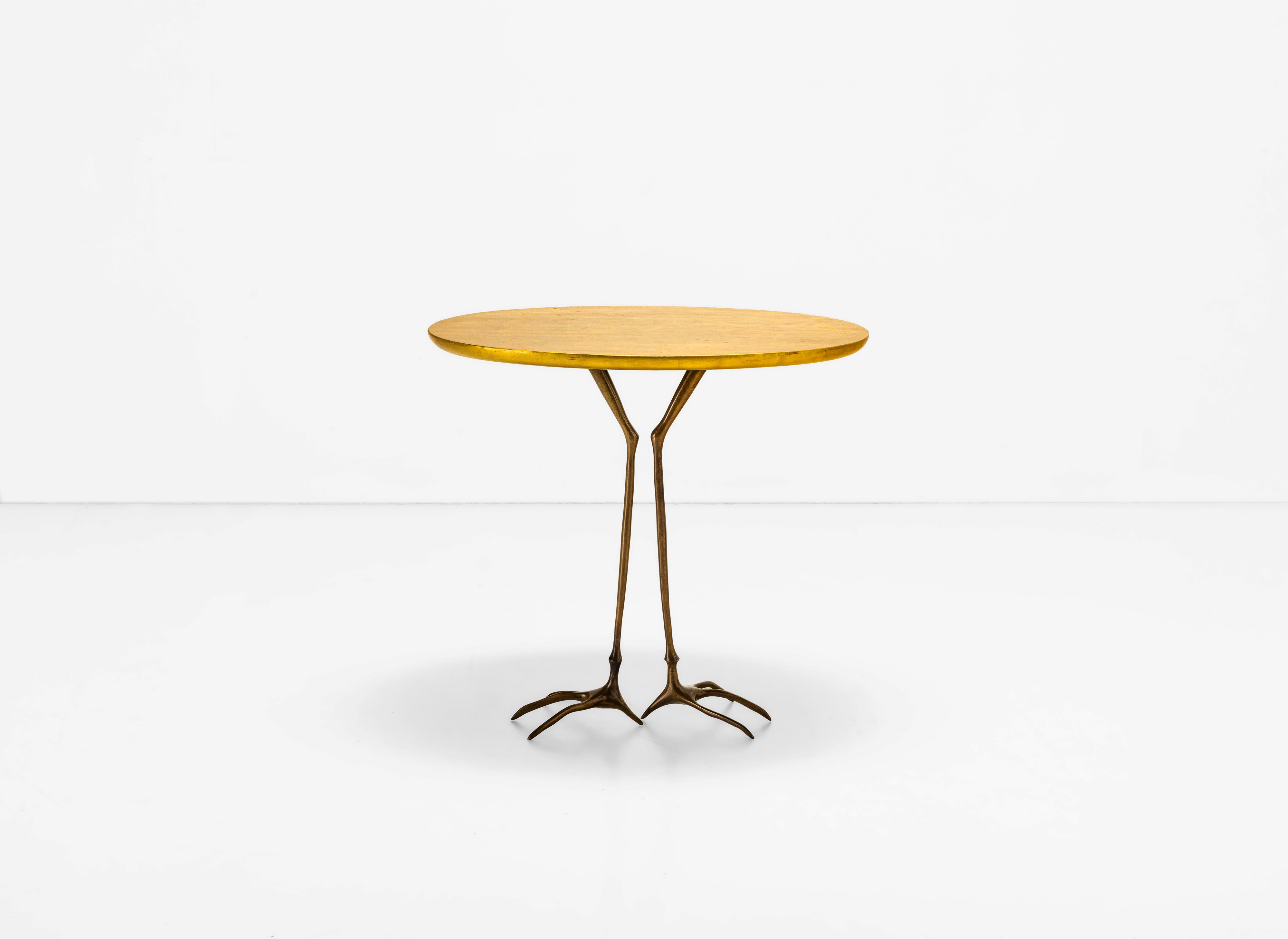 Meret Oppenheim - Tavolo occasionale mod. Traccia, fusione di bronzo dorato e legno a foglia oro