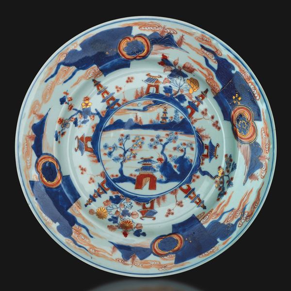 Piatto in porcellana Imari a soggetto paesaggistico con decori a motivi floreali, Cina, Dinastia Qing, epoca Kangxi (1662-1722)