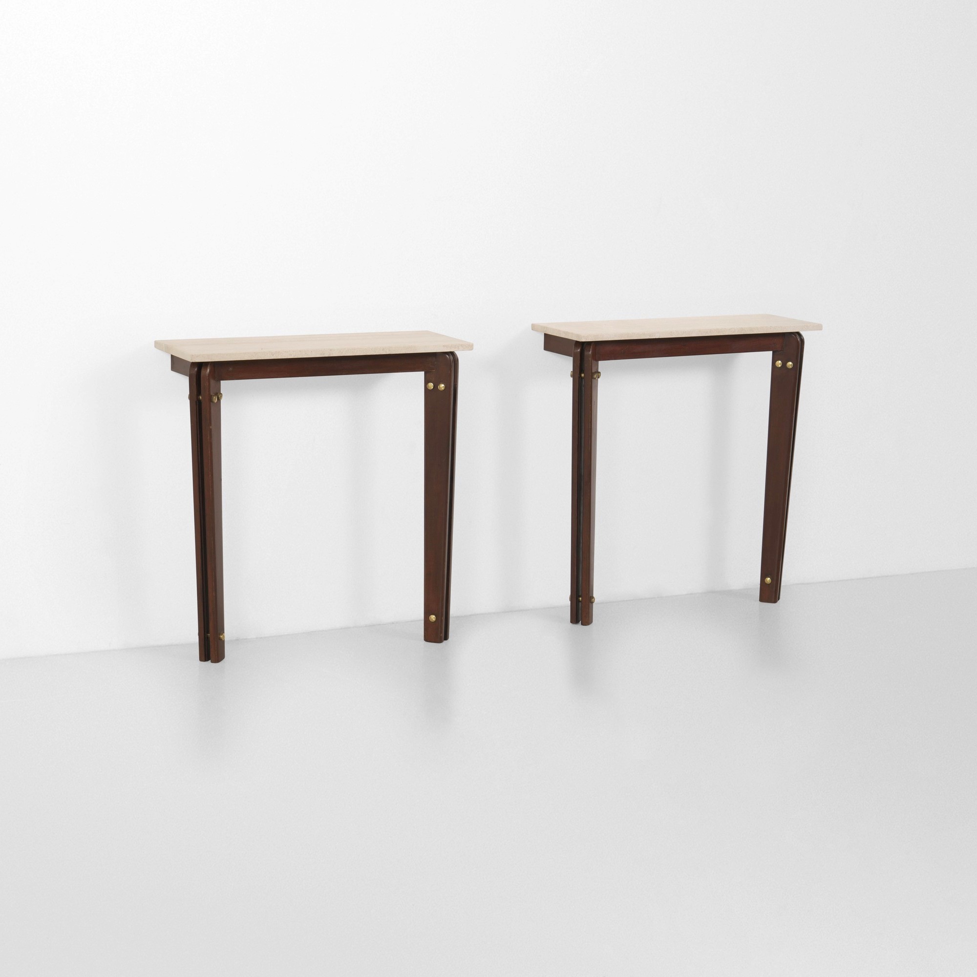 Italia, Due consoles, struttura in legno con piano in travertino e dettagli in ottone, stile indu...
