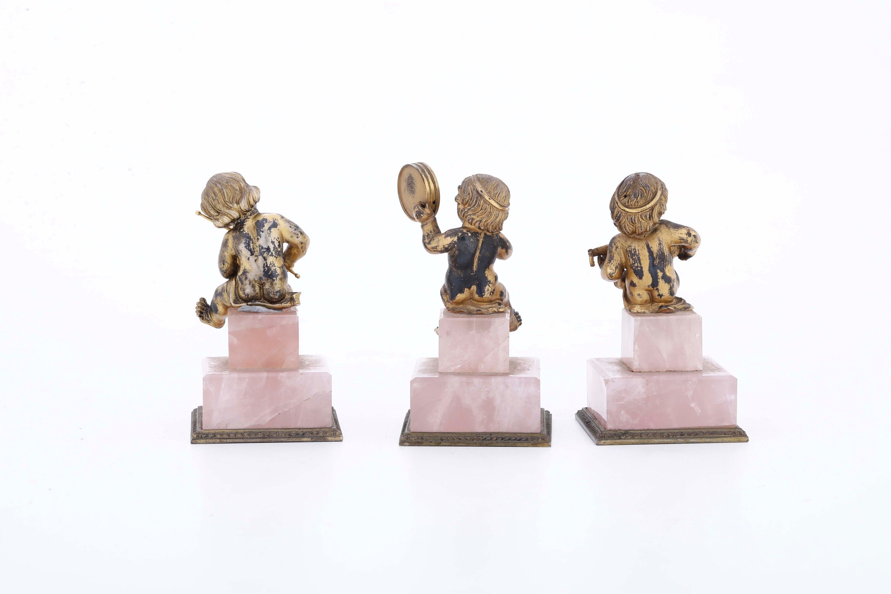Argenteria italiana del XX secolo, Tre putti in argento dorato con basi in quarzo rosa