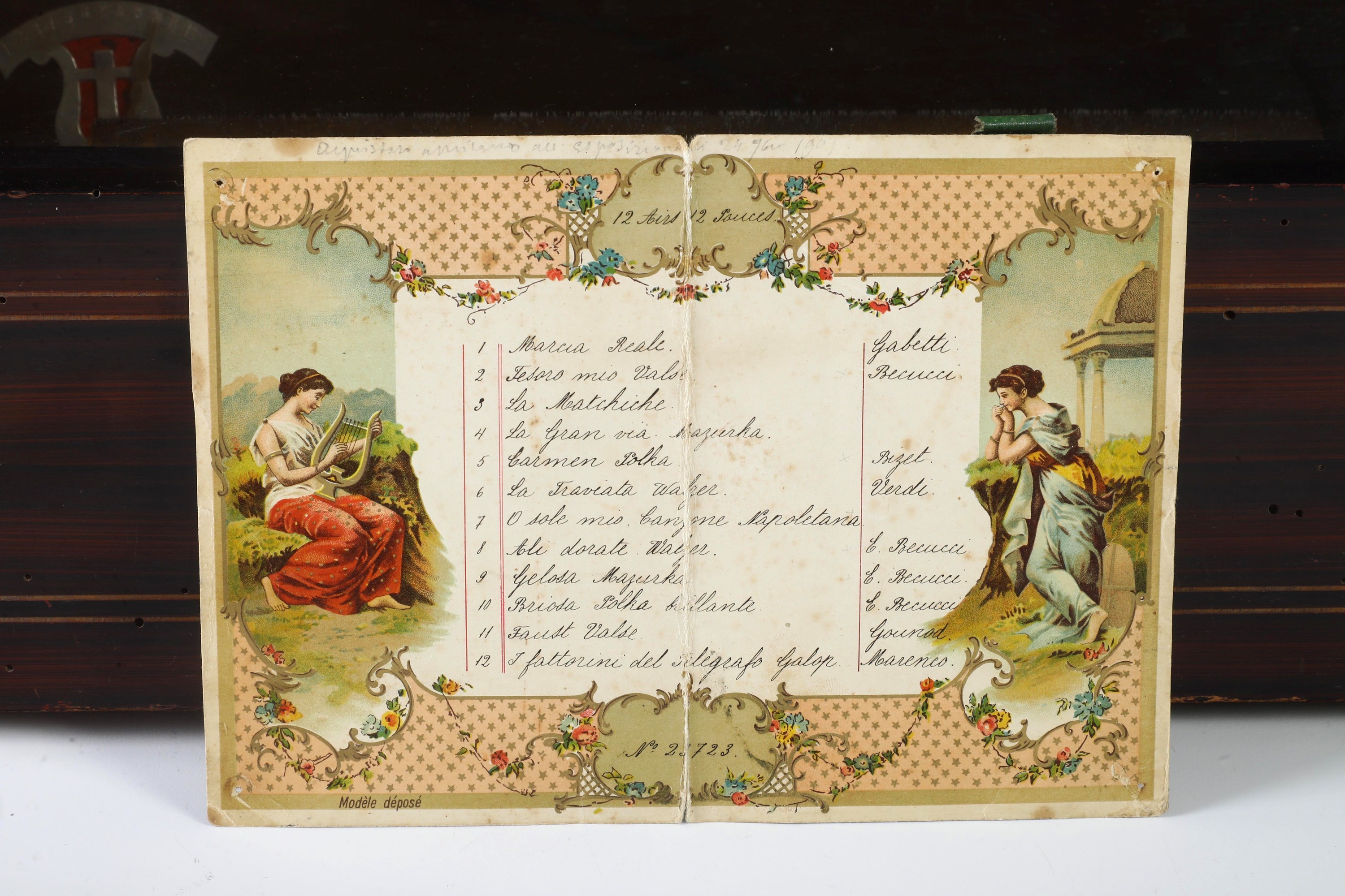 Scatola musicale in legno filettato con coperchio a decoro intarsiato a panoplia musicale
