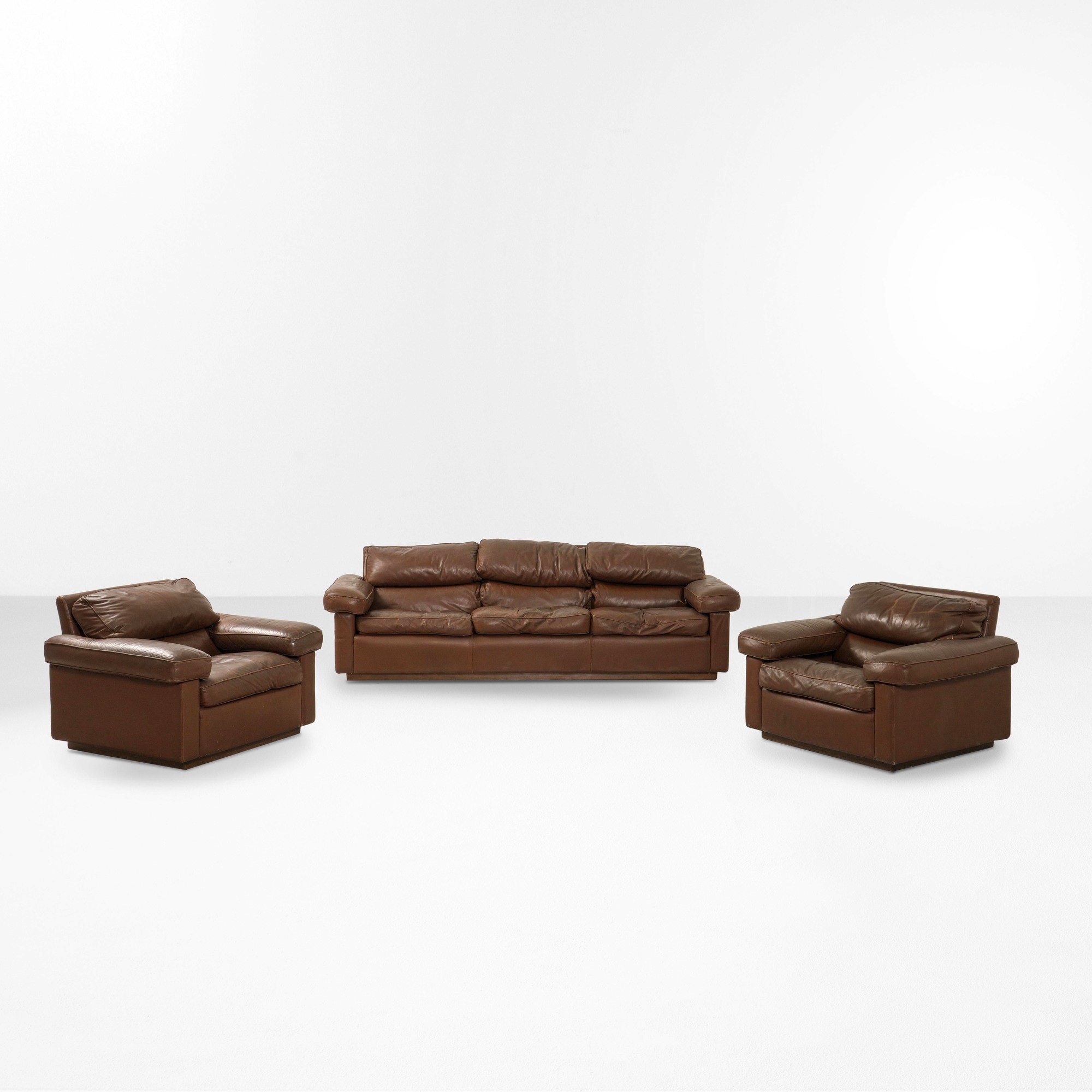 Divano e due poltrone, struttura in legno con rivestimento in cuoio, produzione italiana (circa 1...