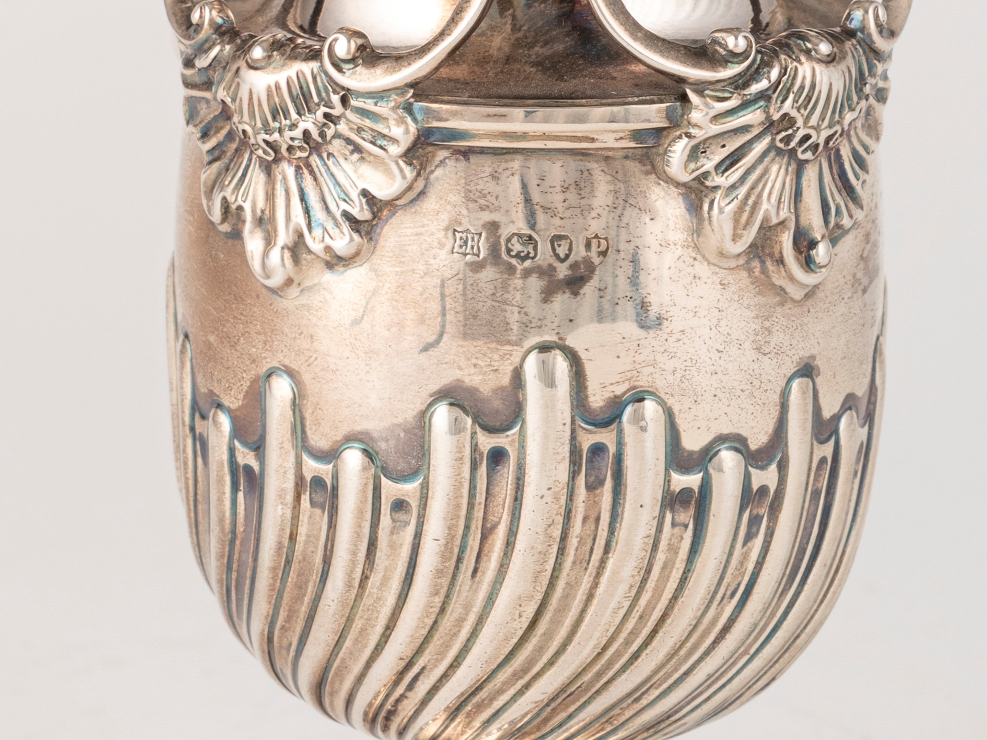 William Hutton & Sons, Spargizucchero (Londra, 1890) in argento fuso sagomato e traforato, con ri...