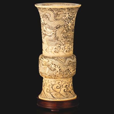 Cina, inizio XIX secolo, Vaso in avorio Zun con decori intagliati a drago e onde