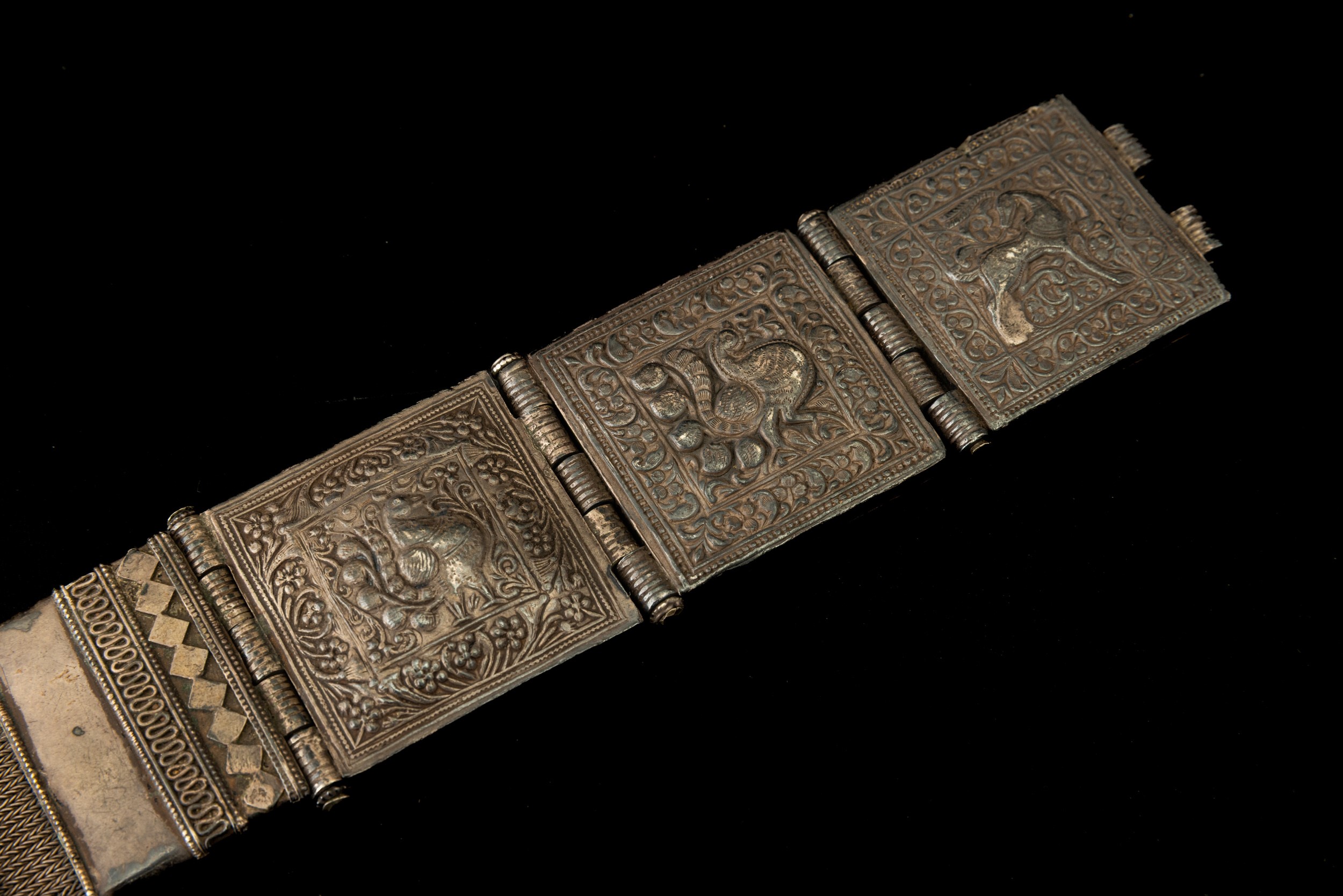 Tibet, Cintura in metallo argentato con decorazioni a rilievo e catena intrecciata,  XIX secolo