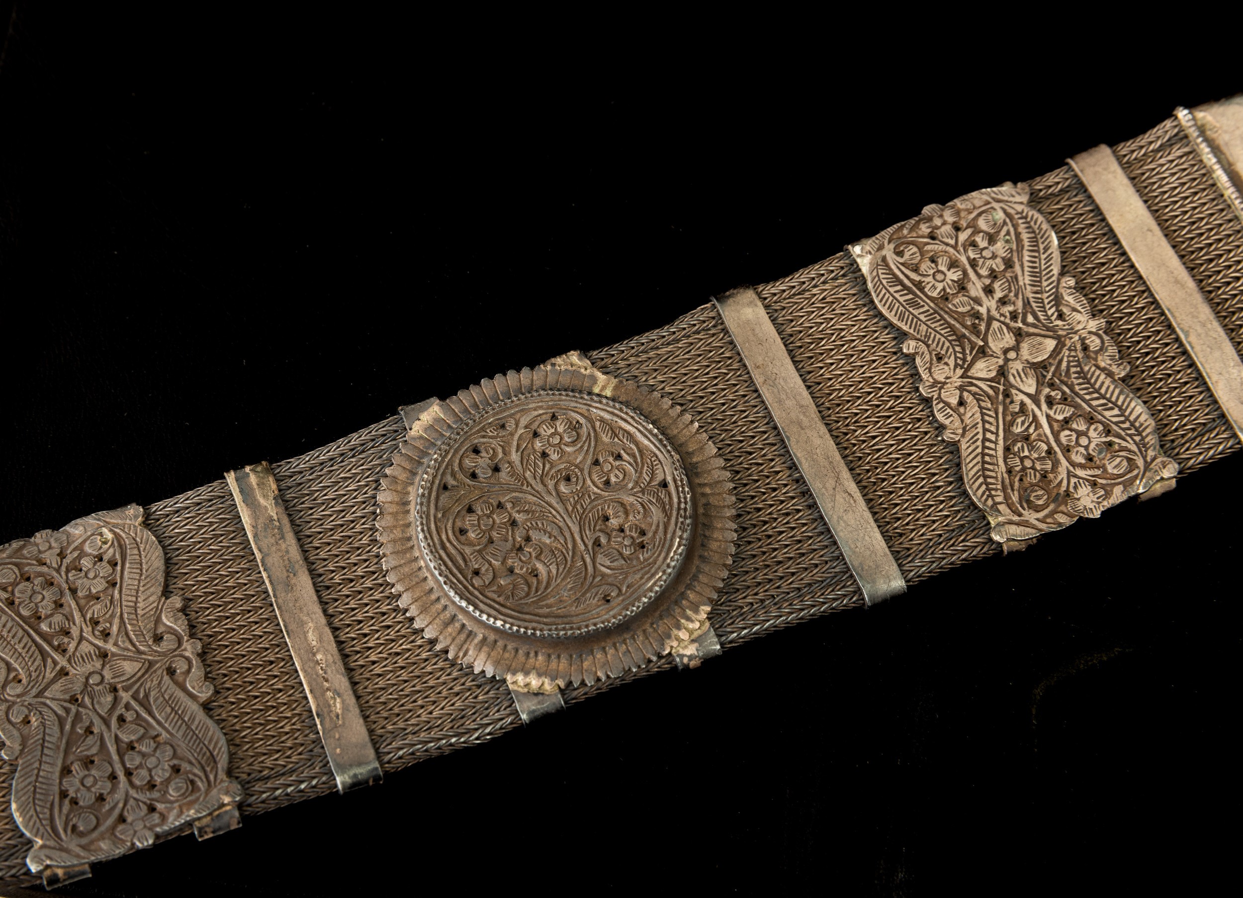 Tibet, Cintura in metallo argentato con decorazioni a rilievo e catena intrecciata,  XIX secolo