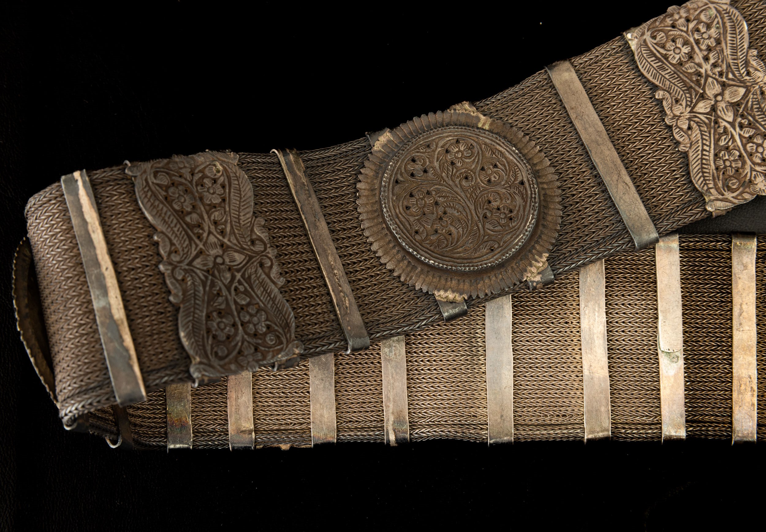 Tibet, Cintura in metallo argentato con decorazioni a rilievo e catena intrecciata,  XIX secolo