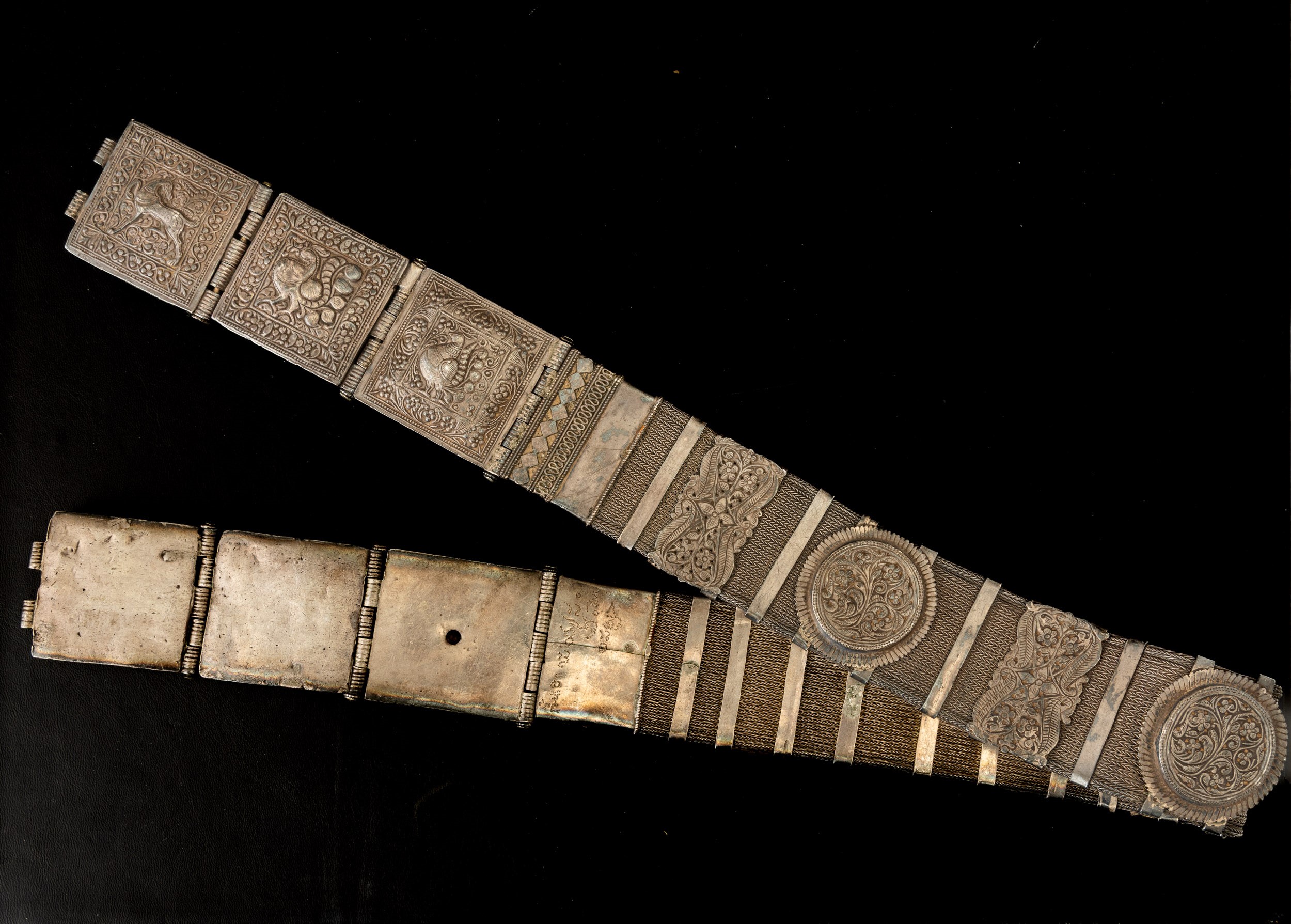 Tibet, Cintura in metallo argentato con decorazioni a rilievo e catena intrecciata,  XIX secolo