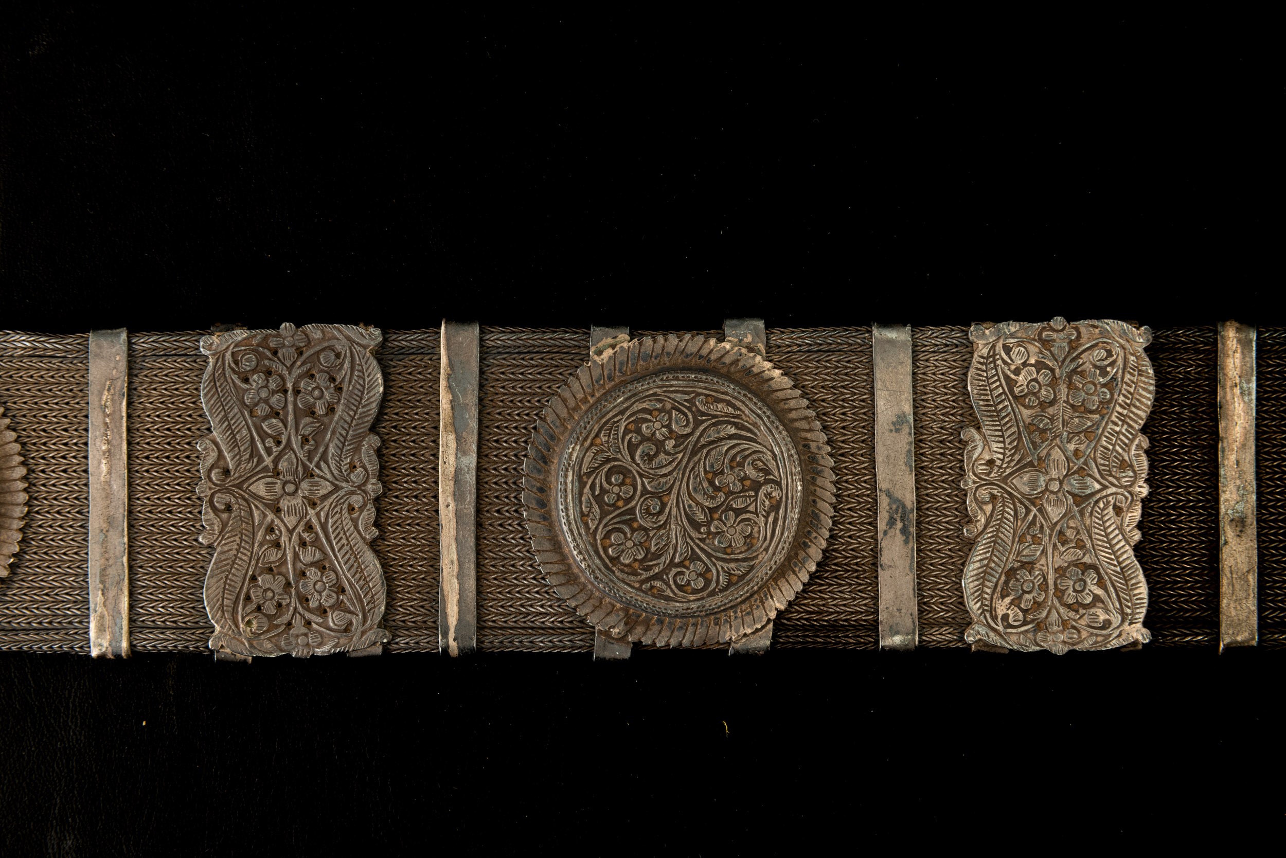 Tibet, Cintura in metallo argentato con decorazioni a rilievo e catena intrecciata,  XIX secolo