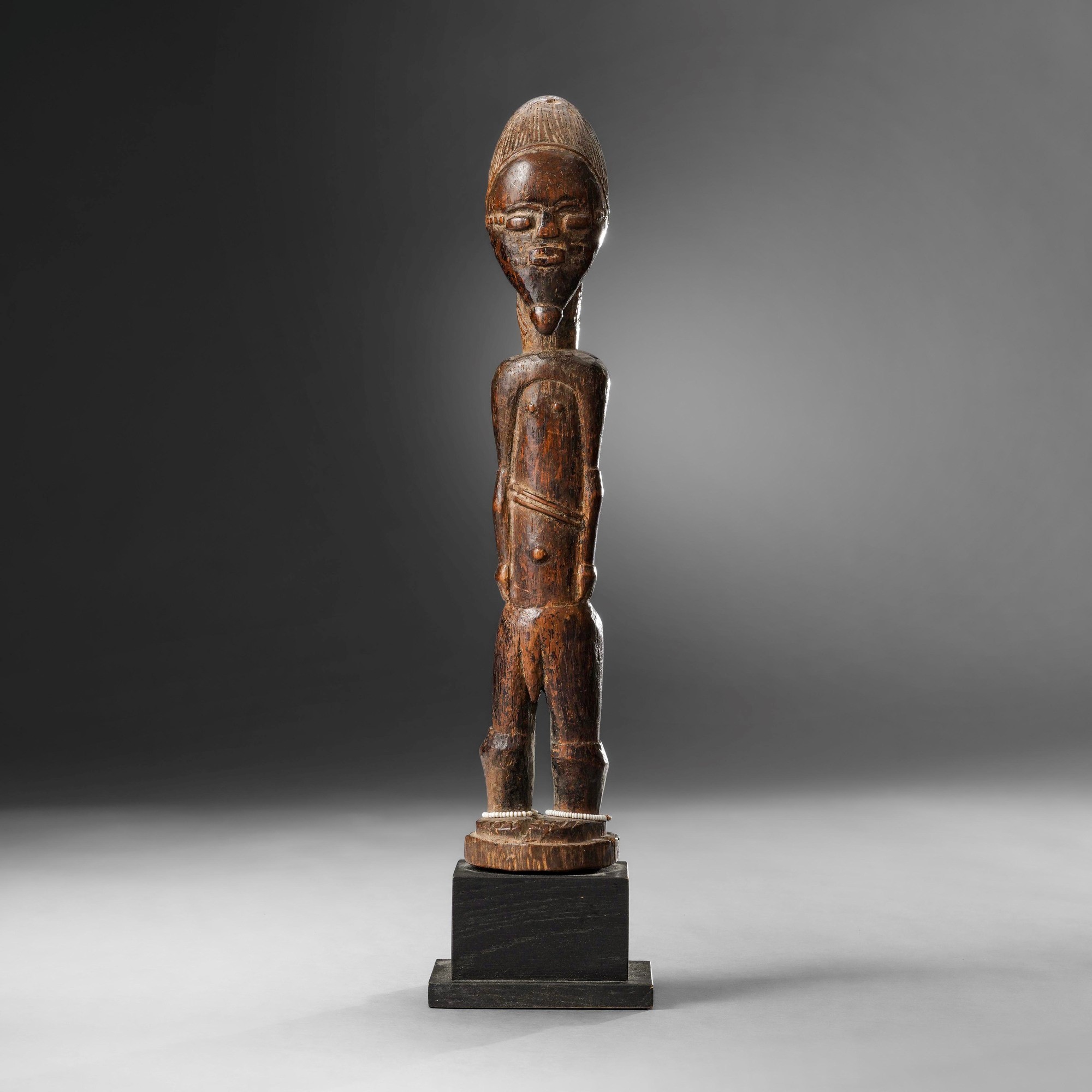 Baoulé, Statua in legno a patina scura con perline, inizio XX secolo