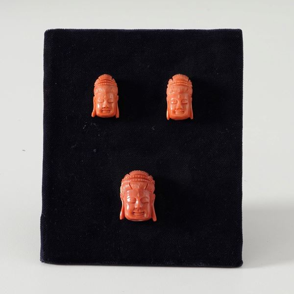 Three coral Buddha heads