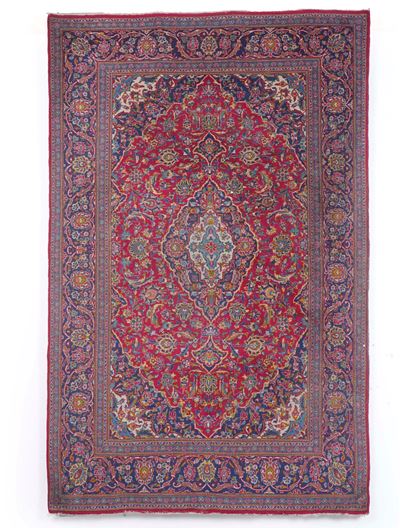 Tappeto persiano, XX secolo, fondo rosso con rosone centrale e decorazioni floreali