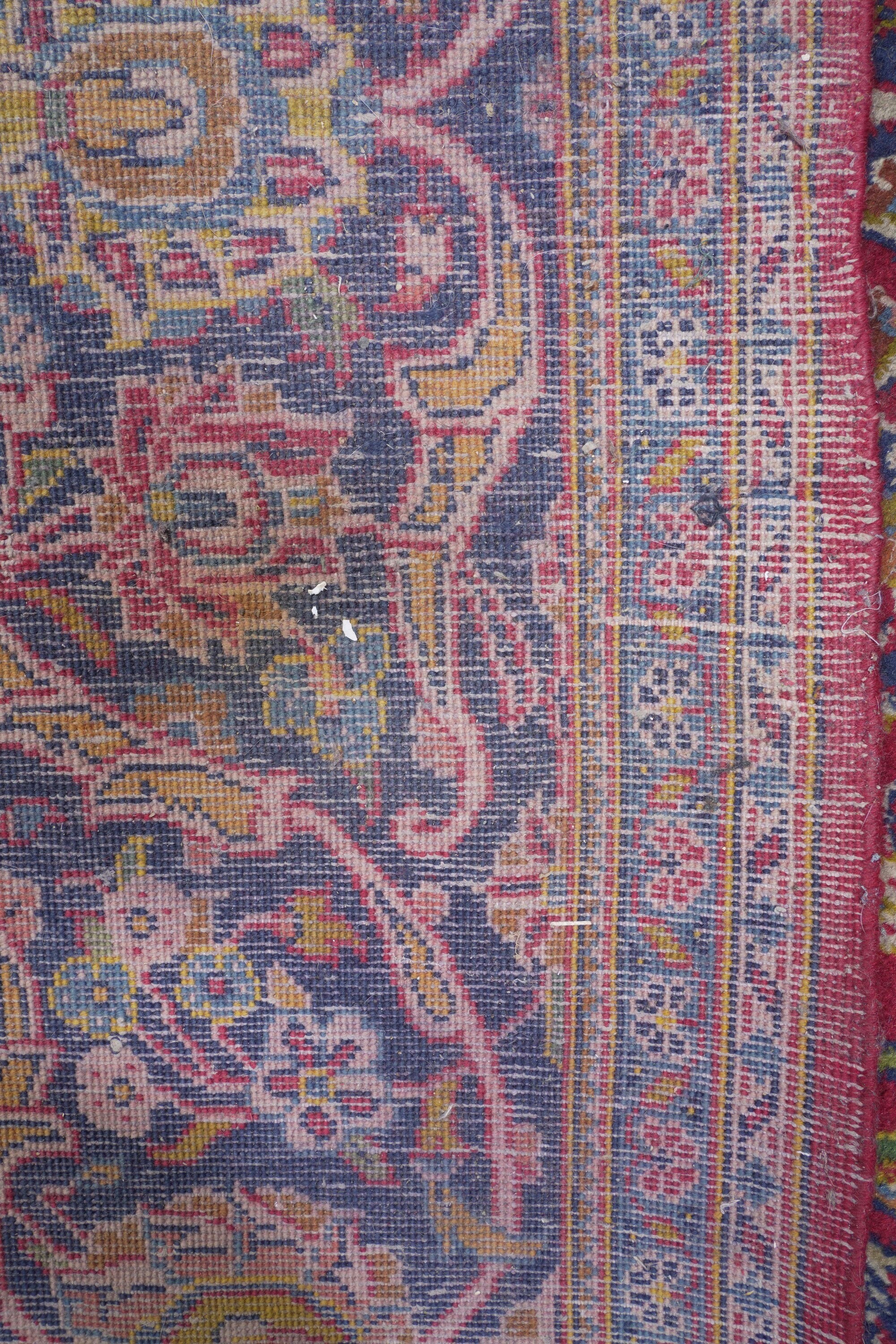 Tappeto persiano, XX secolo, fondo rosso con rosone centrale e decorazioni floreali