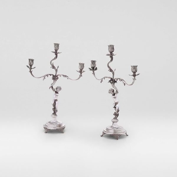 Coppia di candelabri a tre fiamme di gusto neobarocco. Argenteria artistica italiana del XX secolo.