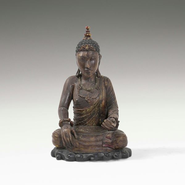 Figura di Buddha in legno con tracce di policromia e collane in materiali vari, Tibet, XX secolo