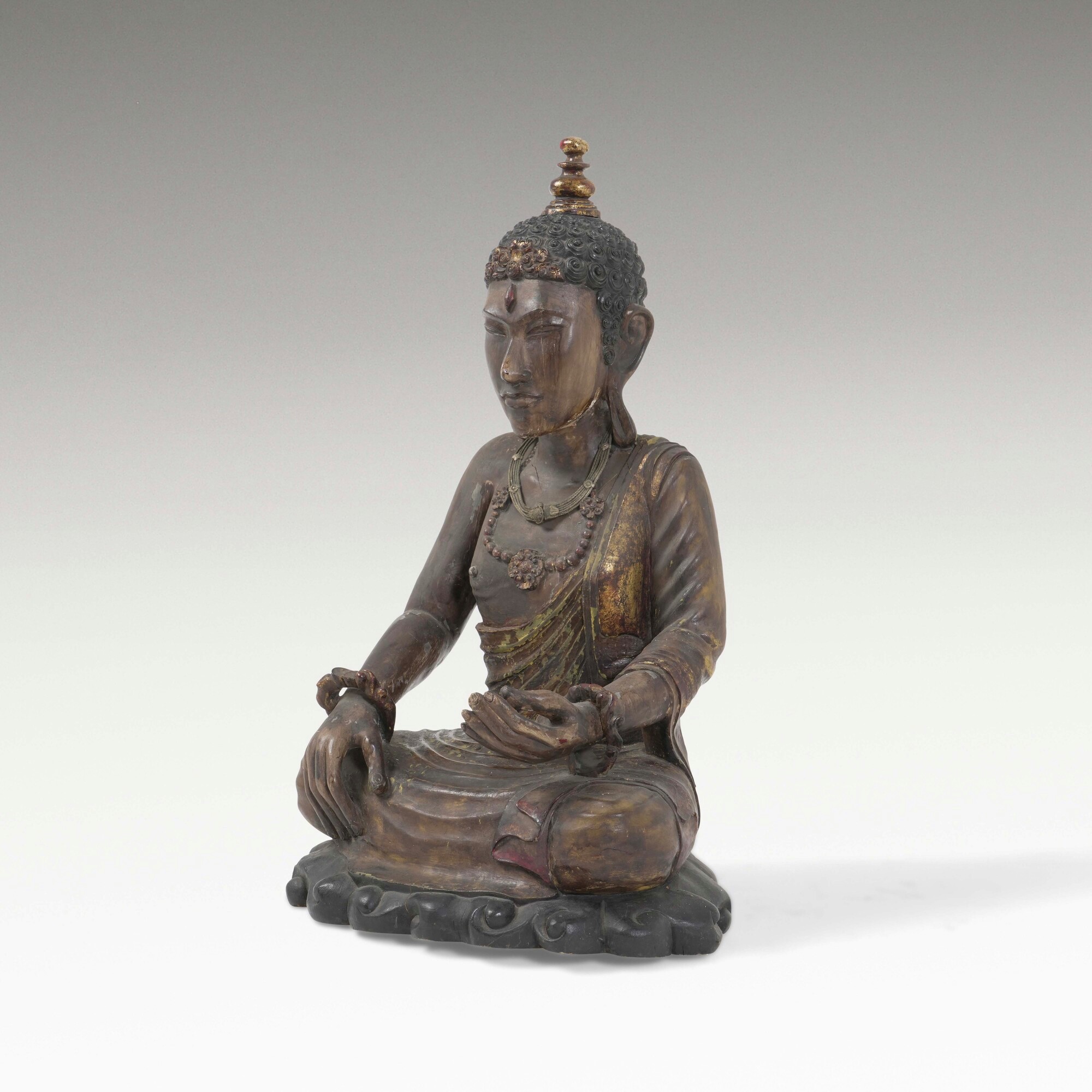 Figura di Buddha, legno con tracce di policromia e collane, Tibet, XX secolo