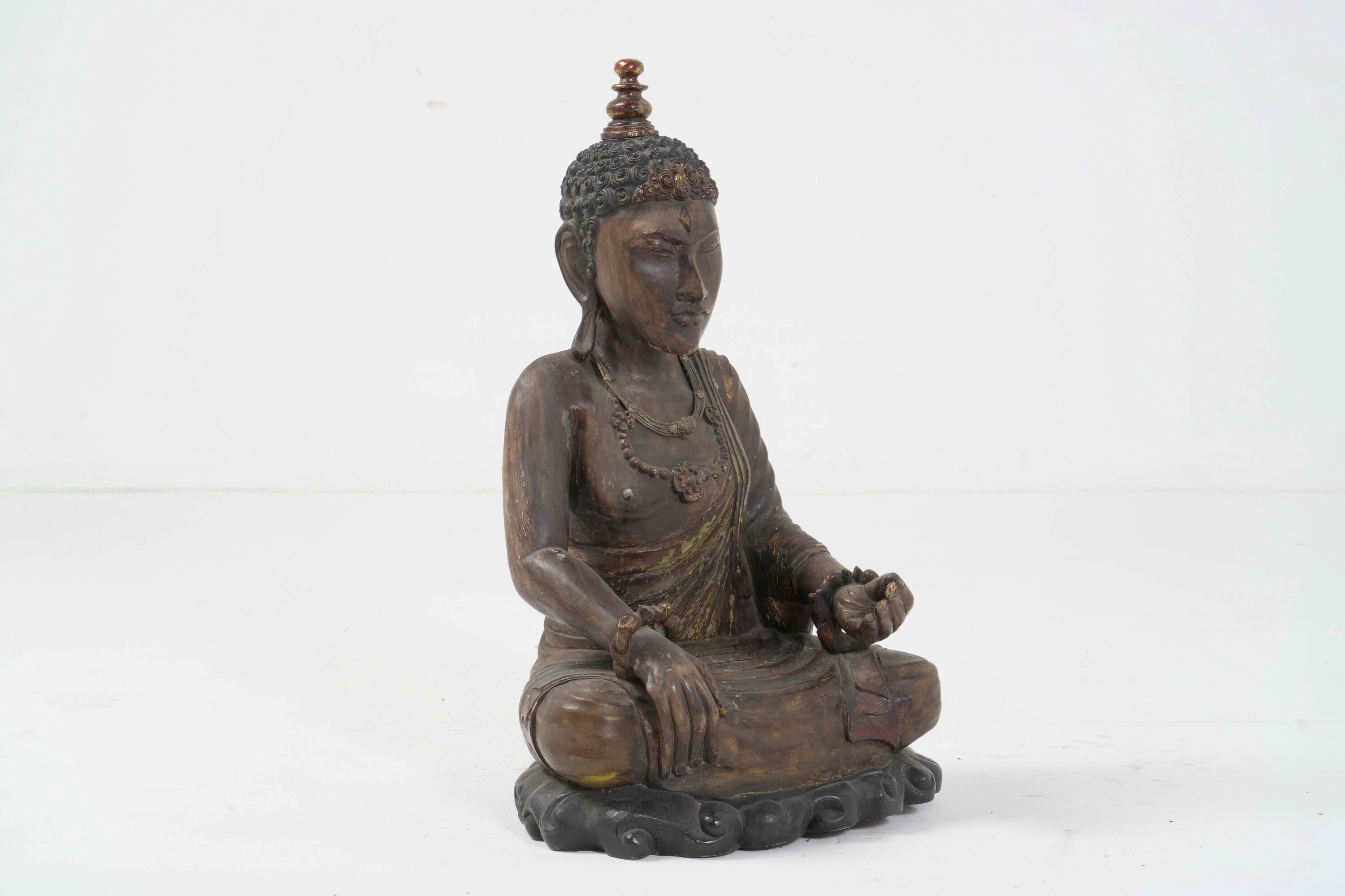 Figura di Buddha, legno con tracce di policromia e collane, Tibet, XX secolo