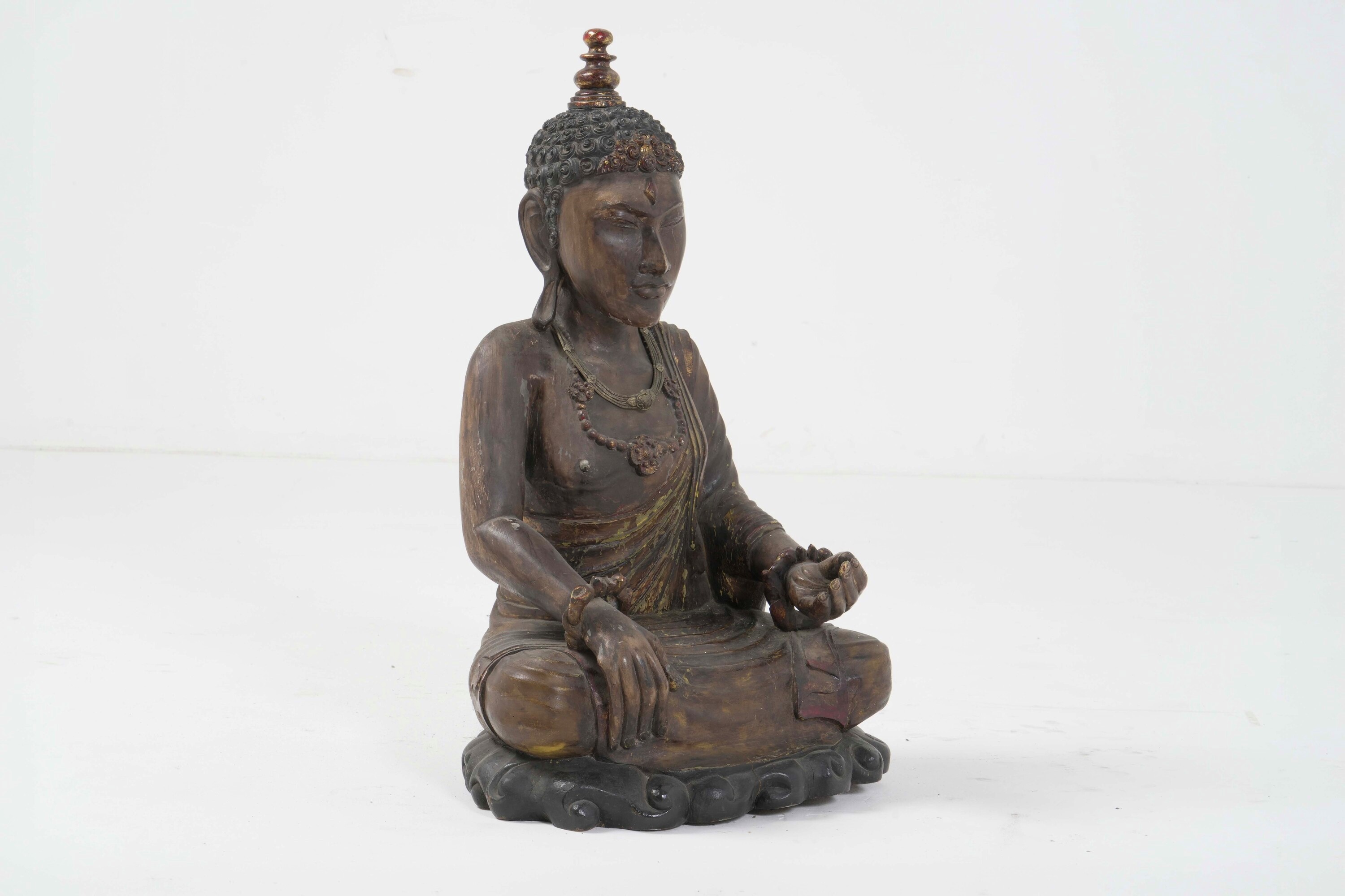 Figura di Buddha, legno con tracce di policromia e collane, Tibet, XX secolo