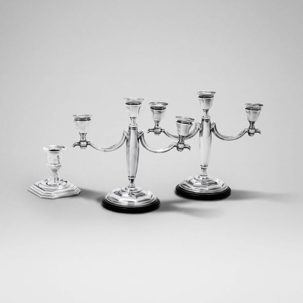Una coppia di candelabri a tre fiamme di modello Decò su base circolare in bachelite. Italia XX secolo.