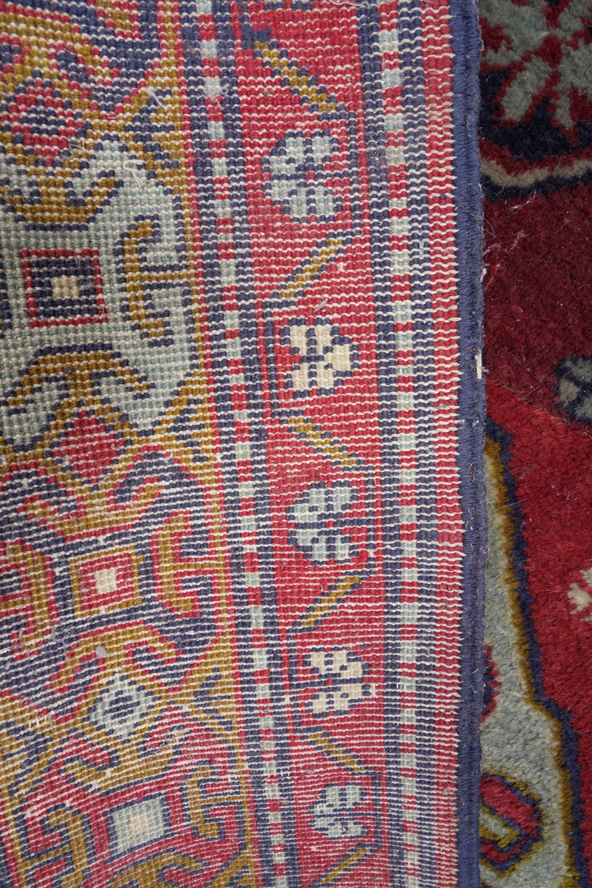 Tappeto persiano, XX secolo, fondo rosso con decori geometrici policromi
