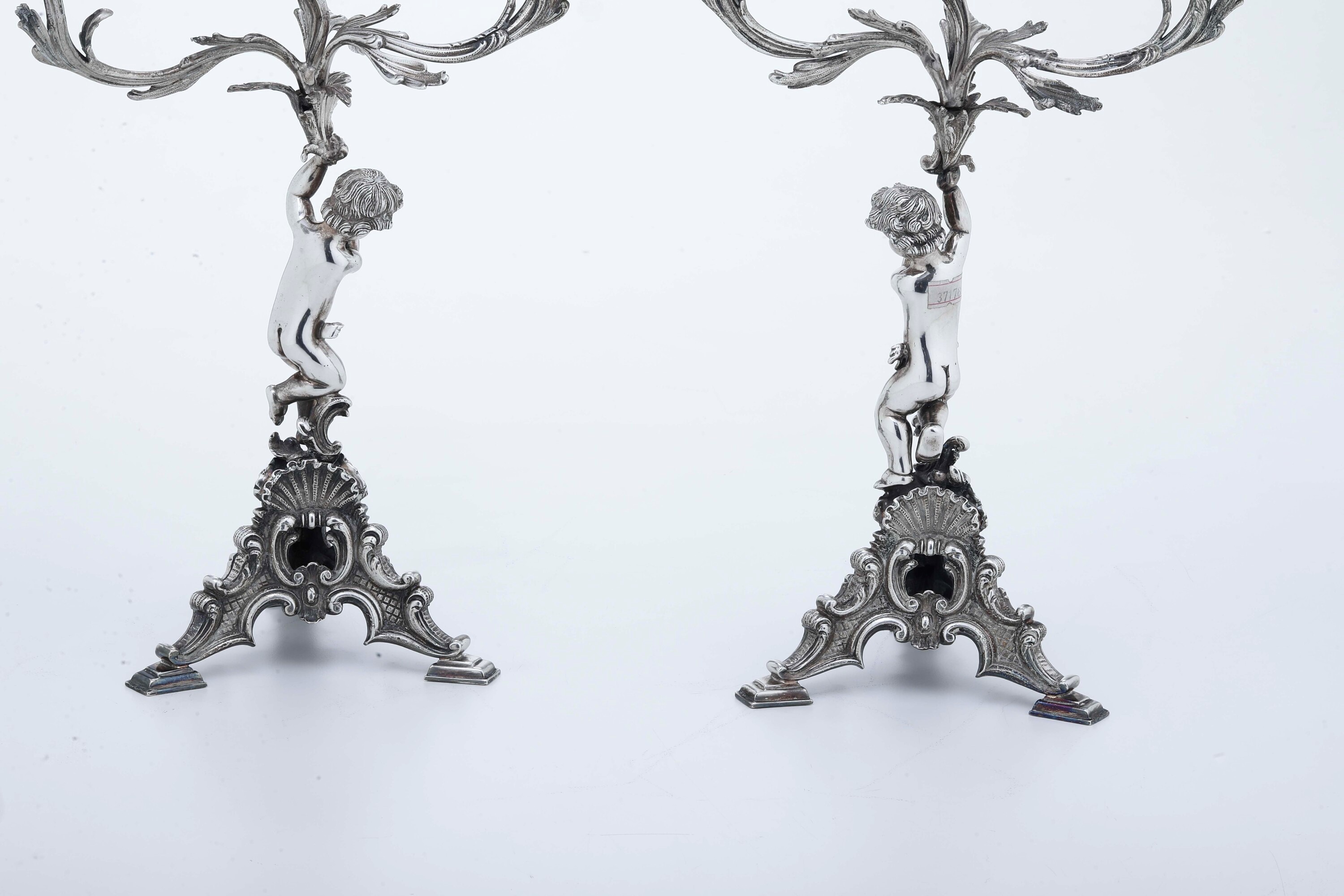 Manifattura italiana del XX secolo, Coppia di candelabri neobarocchi in argento e metallo argenta...