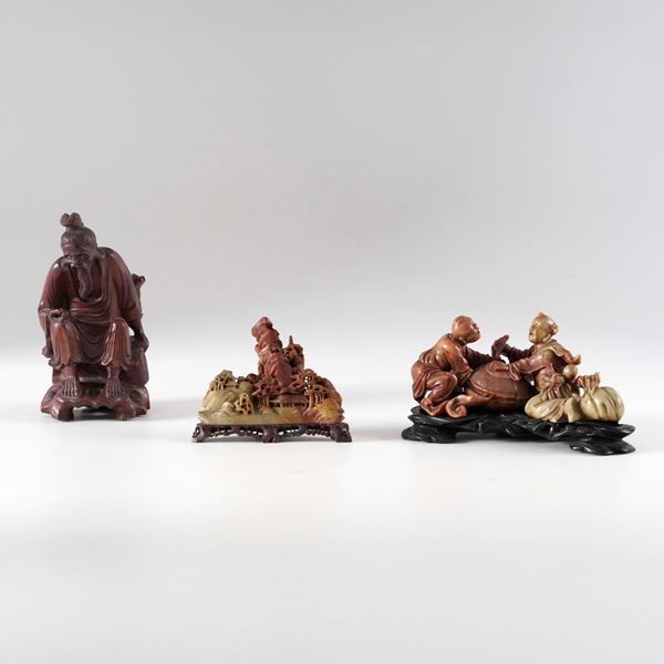 Lotto composto da figura di immortale in legno e due figure di personaggi e paesaggi in pietra saponaria, Cina, XX secolo