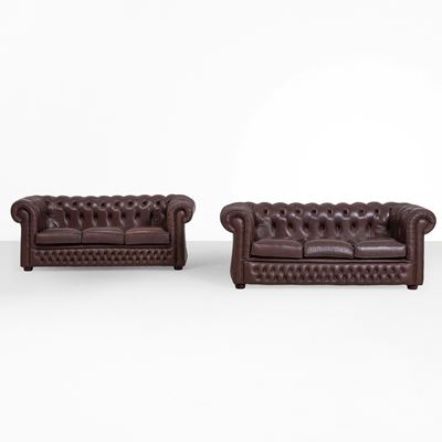 Coppia di divani modello “Chesterfield”, rivestiti in pelle, schienale capitonné (XX secolo)
