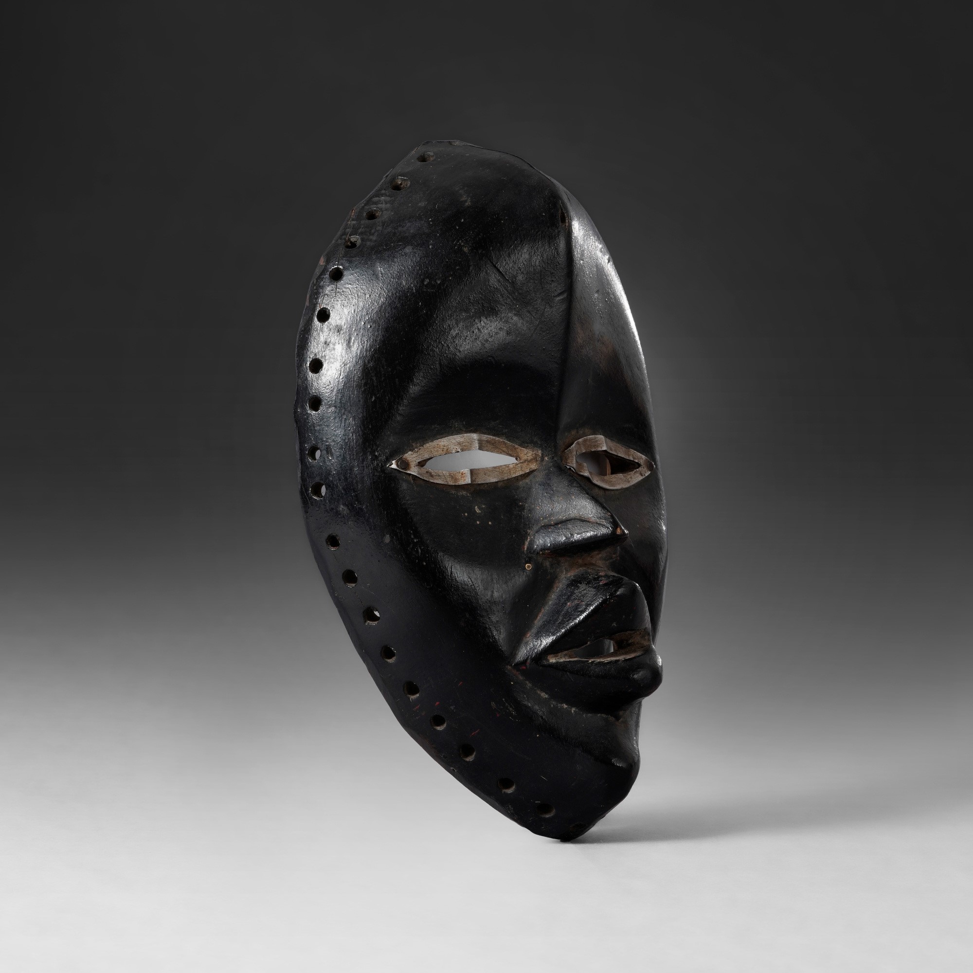 Fedele Papagni, Dan, Costa d'Avorio, Maschera in legno a patina nera con elementi in metallo