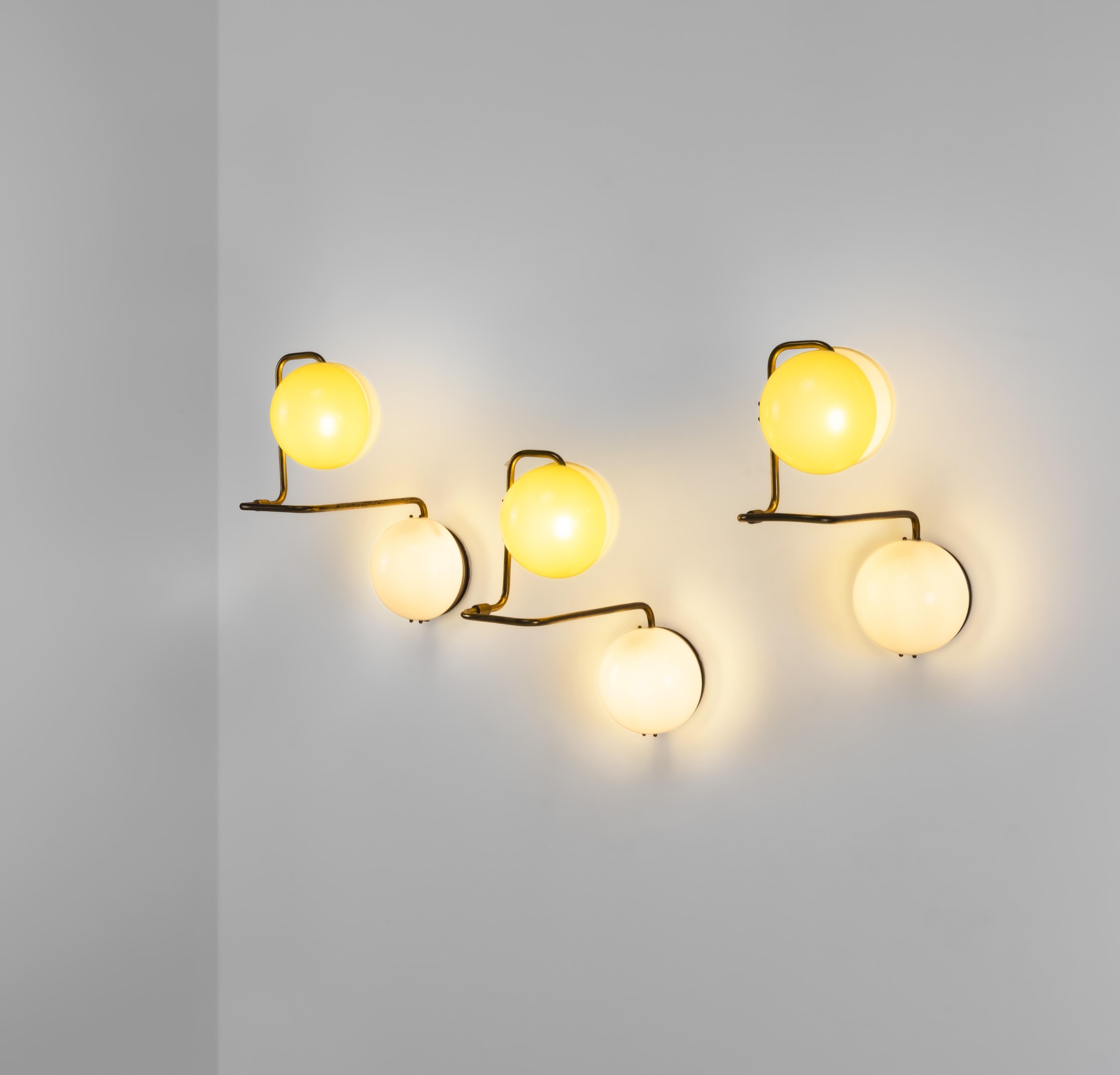 Prodotto in Italia, Tre lampade a parete, struttura in metallo e ottone con diffusori in perspex ...