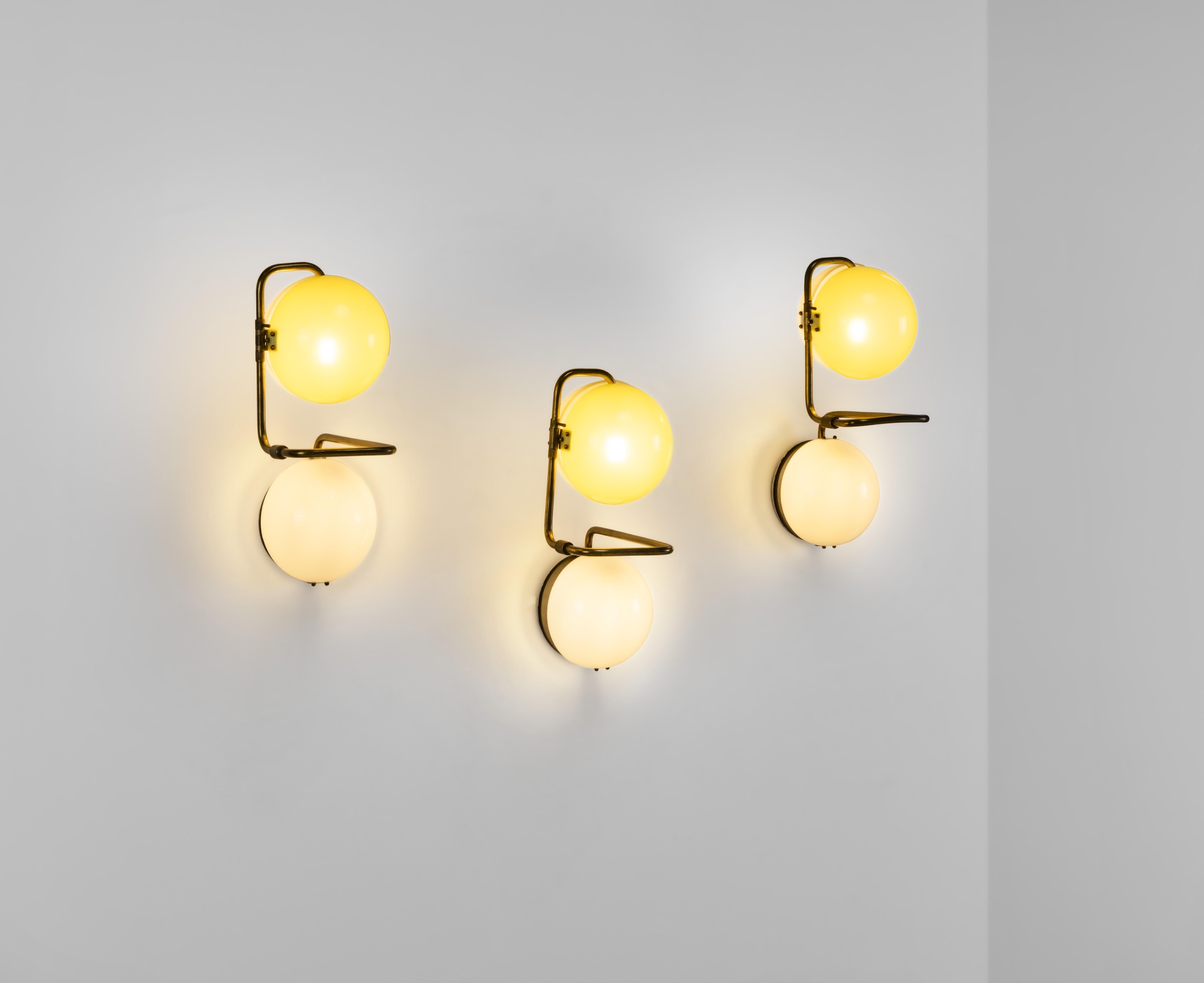 Prodotto in Italia, Tre lampade a parete, struttura in metallo e ottone con diffusori in perspex ...